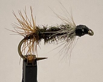 May include: A brown and black fly fishing lure with white feathers and a black bead head.