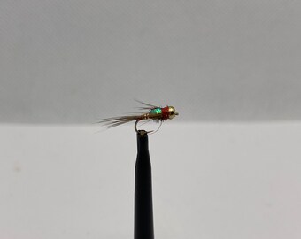 May include: A small, brown and gold fly fishing lure with a red and green bead.
