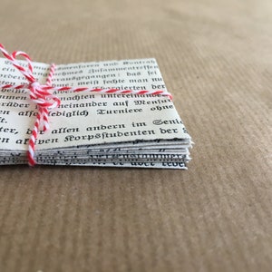 Puede incluir: Una pila de viejas p&aacute;ginas de papel blanco atadas con una cuerda roja y blanca. Las p&aacute;ginas est&aacute;n llenas de texto negro en una fuente tradicional. El texto dice: "Menfumen Ensamenturen unb Ronteah teren sei ein nemed Bufammentreffen bas fei eine Border Доганеgegan rpsstudenten Das hei&szlig;t, en zusammen -Korpsbr&uuml;der Nome: meist feite man nLA Aldebergierten der nachten untereinande neinander auf Mensur bas seien also lediglich Turniere ohne indschaft. e Fechter, der allen andern im Senin ter allen akiven Korpsstudenten der S"