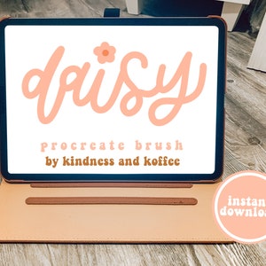 Puede incluir: Una ilustración digital de la palabra "daisy" en color rosa con un pequeño icono de flor rosa sobre la palabra. El texto "Procreate brush by kindness and koffee" está debajo de la palabra daisy. La imagen se muestra en una tableta digital con una funda de cuero marrón. Un círculo rosa con el texto "descarga instantánea" está en la esquina inferior derecha de la imagen.