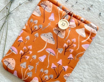 May include: A small orange drawstring bag with a mushroom print and a wooden button closure.