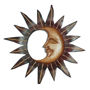 May include: A wooden sun and moon wall hanging with a brown and yellow color scheme. The sun has a starburst design and the moon has a smiling face.