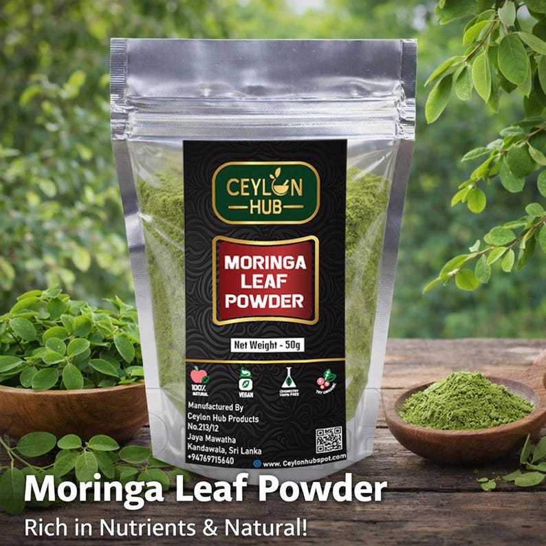 K&ouml;nnte beinhalten: Ein transparenter Beutel mit Moringa-Blattpulver und einem schwarzen und goldenen Etikett. Auf dem Etikett steht "CEYLON HUB" und "MORINGA LEAF POWDER". Das Nettogewicht betr&auml;gt 50g. Das Bild zeigt auch eine Holzschale und einen L&ouml;ffel mit dem Pulver und dem Text "Rich in Nutrients & Natural!"