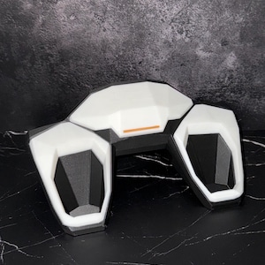 May include: A set of three ceramic mugs with a speckled, matte finish. The mugs are in cream, light grey, and dark grey. Each mug has a simple, minimalist design, ideal for coffee or tea.