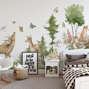 May include: A white wall with a woodland themed mural featuring a deer, a fox, a squirrel, and a badger. The mural also includes trees, flowers, butterflies, and bees. The mural is in a child's bedroom with a white rocking chair, a white nightstand, and a bed with a black and white patterned duvet cover. The text "exist to be happy it to press" is on a black framed print.