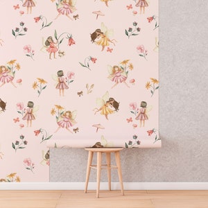 May include: Pink wallpaper with a repeating pattern of fairies, flowers, and butterflies. The wallpaper is rolled up on a wooden stool.