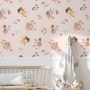 May include: Pink wallpaper with a repeating pattern of fairies, flowers, and butterflies. The wallpaper is shown in a room with a white wainscoting, a wooden bench, and a basket of toys.