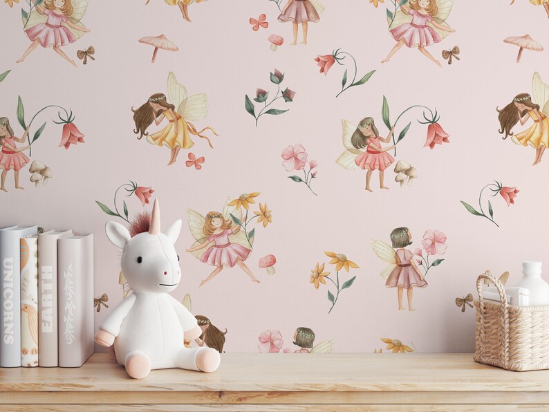 May include: Pink wallpaper with a repeating pattern of fairies, flowers, and mushrooms. The fairies are wearing yellow, pink, and red dresses with wings. The flowers are in shades of pink, yellow, and red. The mushrooms are brown. A white stuffed unicorn is sitting in front of the wallpaper.