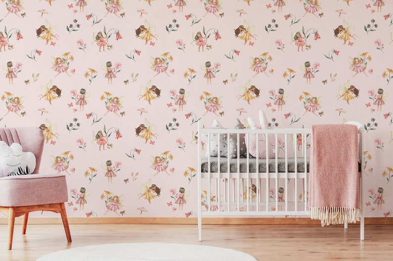 May include: Pink nursery wallpaper with a repeating pattern of fairies holding flowers and butterflies. The wallpaper is in a room with a white crib and a pink armchair.