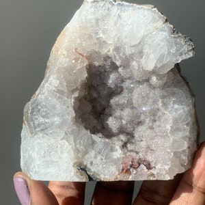 K&ouml;nnte beinhalten: Ein wei&szlig;er Kristallgeode mit einer gro&szlig;en, offenen H&ouml;hle. Das Innere des Geoden ist mit kleinen, wei&szlig;en Kristallen ausgekleidet. Der Geode hat ein raues, nat&uuml;rliches &Auml;u&szlig;eres.