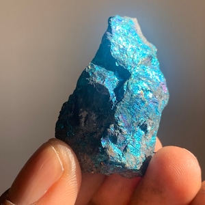 May include: A rough, dark blue and iridescent mineral specimen with a metallic sheen.