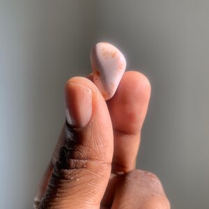 以下が含まれることがあります： 滑らかな表面を持つ、ピンクとオレンジの小さな不規則な形の石