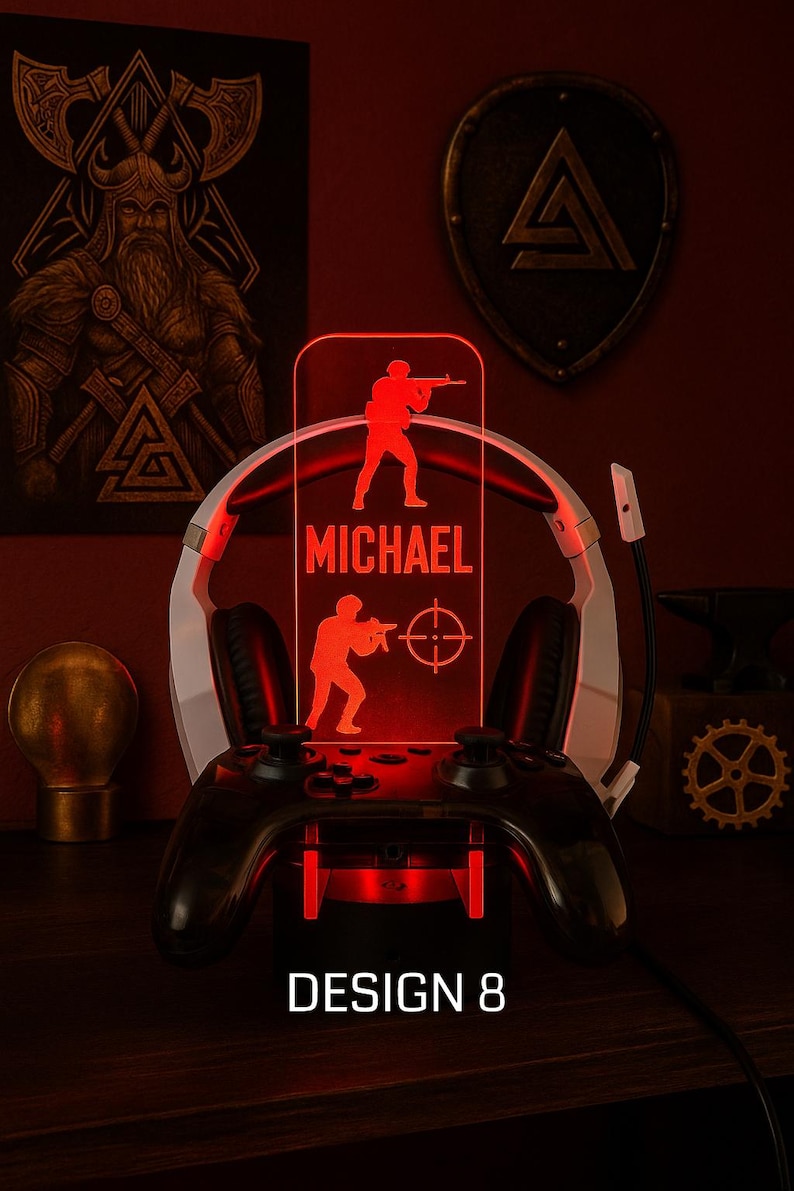 May include: A red LED gaming lamp with a personalized name and soldier silhouettes. The lamp sits on a black game controller base, with a white and black headset behind it. The text "DESIGN 8" is at the bottom.