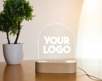 May include: A white acrylic sign with the text "YOUR LOGO" on a wooden base. The sign is illuminated from behind, creating a soft glow.