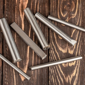 Pu&ograve; includere: Un set di sette strumenti in metallo argentato con punte di diverse forme, disposti su una superficie in legno marrone scuro.
