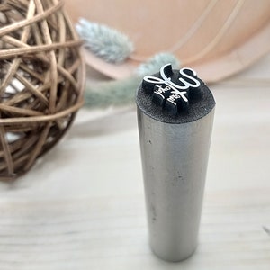 May include: A silver metal stamp with the text "You are my sun" engraved on the top.