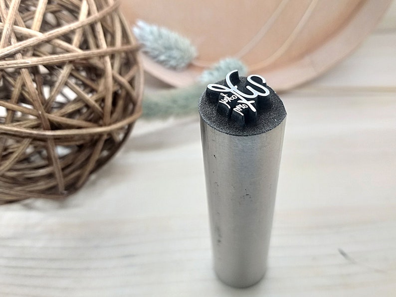 May include: A silver metal stamp with the text "You are my sun" engraved on the top.