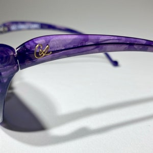 May include: Purple sunglasses with a rose design on the side and the word "Cole" in gold lettering on the frame.