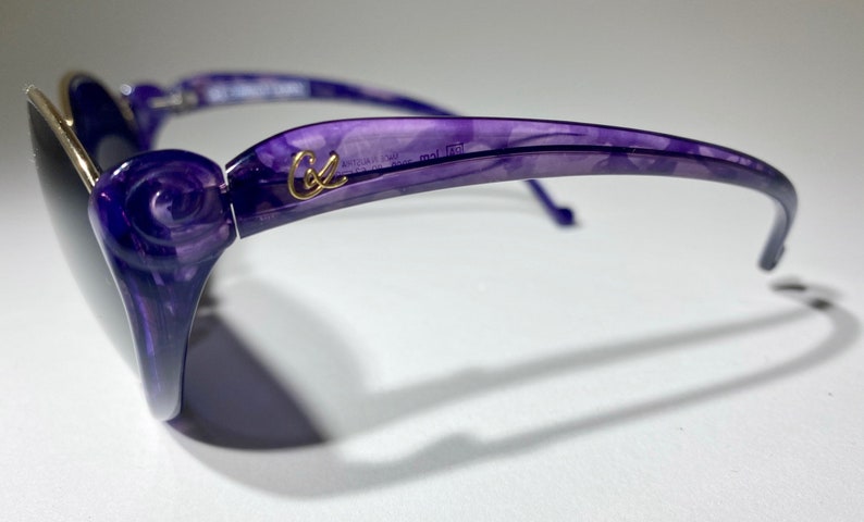 May include: Purple sunglasses with a rose design on the side and the word "Cole" in gold lettering on the frame.