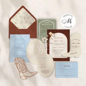 May include: A wedding stationery suite featuring a rust-colored envelope with a patterned liner, a light blue Save the Date, a dark brown invitation, a boot-shaped card, and RSVP cards in cream and blue, all decorated with western-themed illustrations.