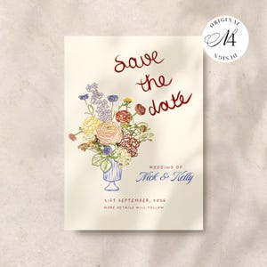 Könnte beinhalten: Eine cremefarbene Save the Date-Karte mit einem bunten Blumenstrauß in einer blauen Vase. Der Text lautet Save the date, Wedding of Nick & Kelly, 21st September, 2026 und More details will follow. Ein kreisförmiges Logo zeigt Original Design M4.
