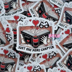 May include: A collection of stickers featuring a book with the word "SMUT" on the pages. The book is held by hands and surrounded by hearts, glasses, and the text "JUST ONE MORE CHAPTER".