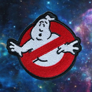 May include: Embroidered patch featuring the Ghostbusters logo. The design includes a white ghost figure inside a red circle with a red slash through it. The patch has a black border and is set against a space-themed background.