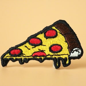 May include: A yellow and red embroidered iron-on patch of a pizza slice with melted cheese dripping down the sides.