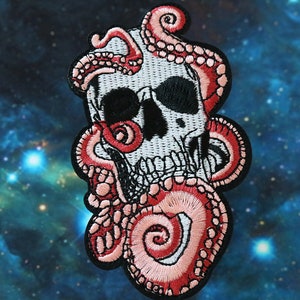 May include: Embroidered patch featuring a white skull with black eye sockets and a jawline, surrounded by red and pink tentacles. The patch has a black border and is set against a blue and purple galaxy background.