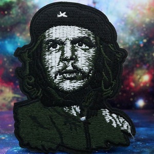 May include: Embroidered patch featuring a black and white portrait of Che Guevara wearing a black beret with a star. The background is a dark green colour.