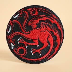 May include: Red embroidered patch with a black background featuring a three-headed dragon, a popular symbol from the TV show Game of Thrones.