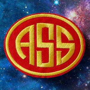 Op de afbeelding: Een geborduurde patch in rood en goud met de letters "ASS" in een cirkel.