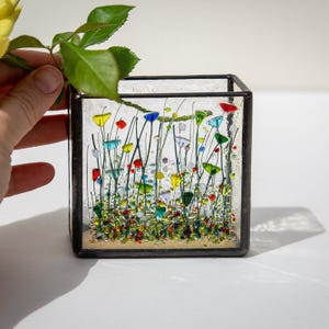 May include: A white ceramic mug with a black handle and the text "But First, Coffee" in a handwritten style. The mug is on a white surface. The mug is approximately 10 cm tall.