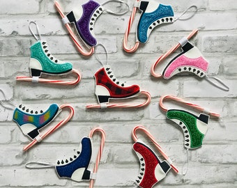 May include: Nine colorful ice skate ornaments attached to candy canes. The ornaments are made of felt and have glitter accents. The candy canes are red and white.