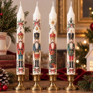 May include: Four white taper candles standing in brass holders, each decorated with a colorful nutcracker figure. The designs include nutcrackers in red, blue, and green uniforms, accented with holly, bows, stars, and small gift boxes.