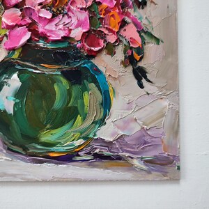 Puede incluir: Pintura al &oacute;leo impasto de un ramo de flores rosas y naranjas en un jarr&oacute;n de cristal verde azulado. La obra presenta pinceladas gruesas y una superficie texturizada, con un fondo neutro y un toque de morado.