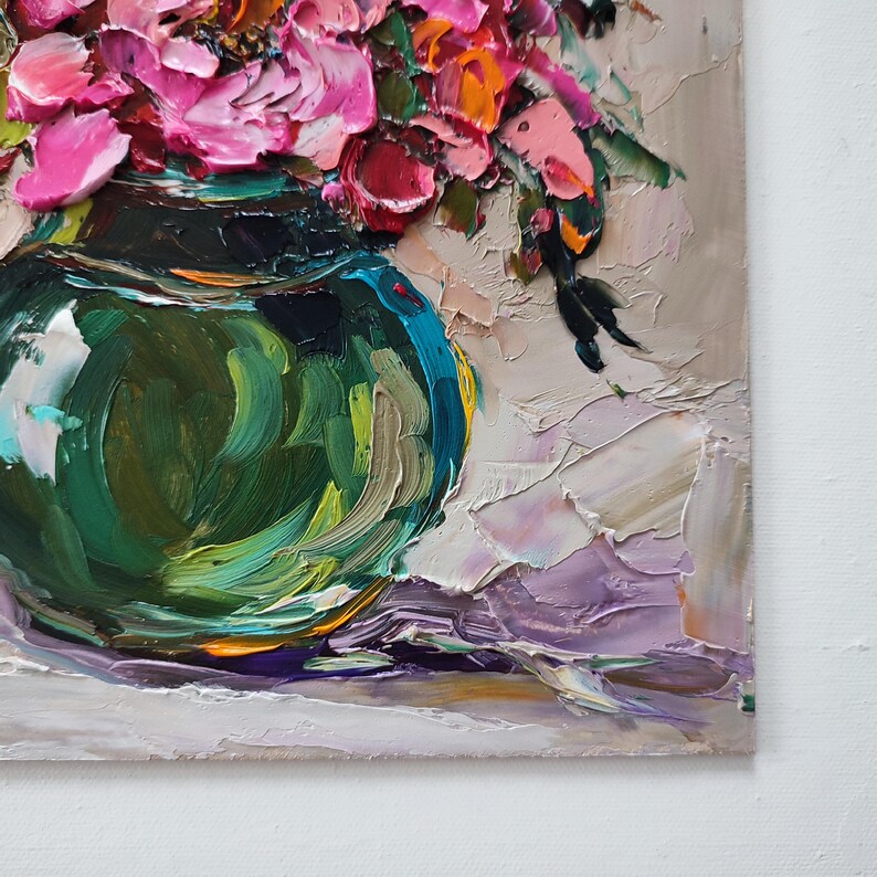 Puede incluir: Pintura al &oacute;leo impasto de un ramo de flores rosas y naranjas en un jarr&oacute;n de cristal verde azulado. La obra presenta pinceladas gruesas y una superficie texturizada, con un fondo neutro y un toque de morado.