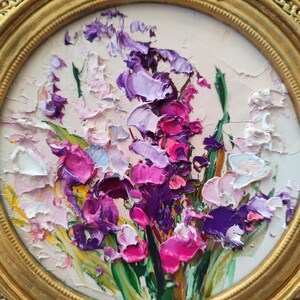 May include: An oil painting in a round gold frame featuring a thick impasto floral arrangement. The composition displays vibrant shades of purple, magenta, pink, and white petals with green leaves, created with heavy, textured brushstrokes on canvas.