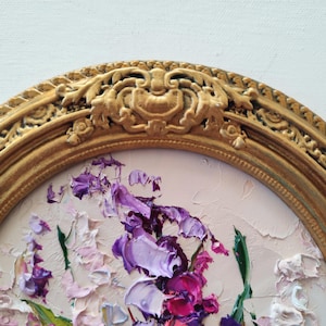 May include: An oval painting featuring thick, textured impasto oil paint strokes in shades of purple, magenta, and white, depicting floral elements. The artwork is encased in an ornate, antique-style gold frame with detailed relief carvings.