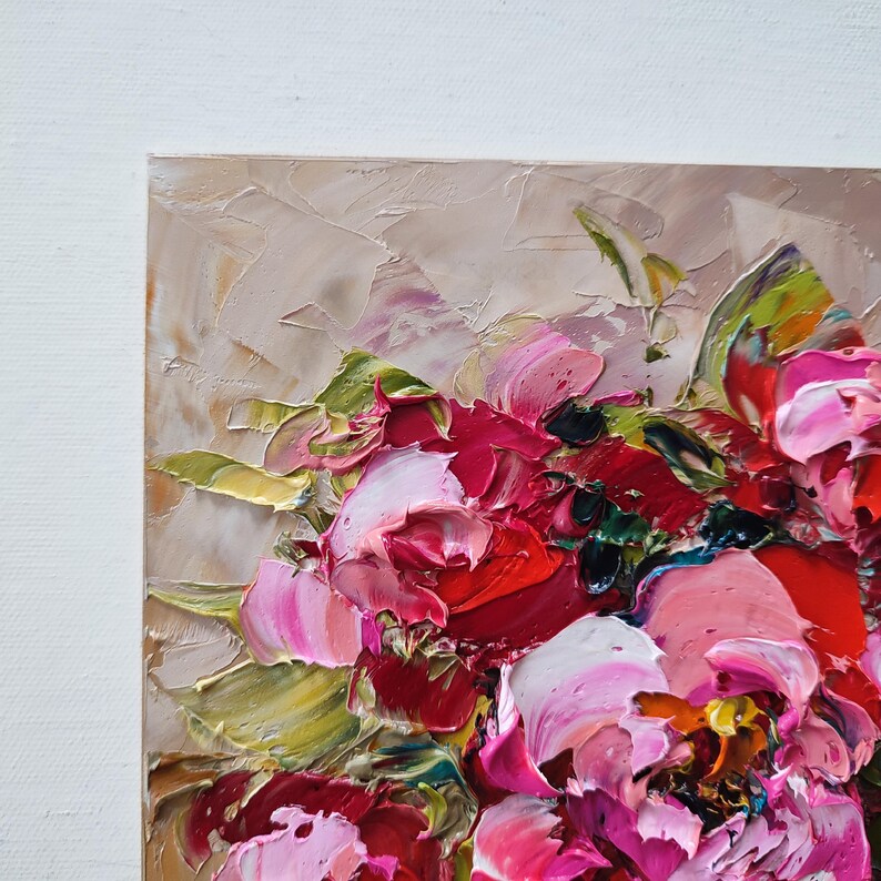 Puede incluir: Primer plano de una pintura al &oacute;leo que representa un ramo de peon&iacute;as. Las flores est&aacute;n pintadas en tonos de rosa, rojo y blanco, con hojas verdes. La pintura tiene un estilo texturizado, impasto, con pinceladas visibles. El fondo es beige neutro.
