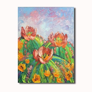 以下が含まれることがあります： ピンクとオレンジの花が咲いたサボテンの絵。サボテンは緑色で、表面はざらざらしている。背景は薄い青色で、ピンク色の雲がある。