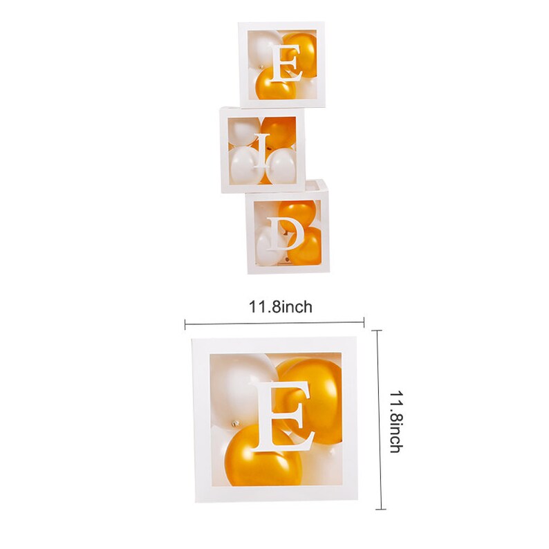 May include: Four white boxes stacked on top of each other, each box contains gold and white balloons and a letter, spelling out the word "EID". The boxes are 11.8 inches tall.