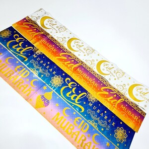 May include: A set of five colorful banners with gold lettering that reads "Eid Mubarak". The banners are decorated with stars, crescent moons, and intricate patterns.
