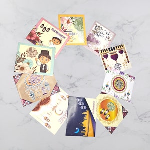 May include: A set of ten colorful greeting cards with Islamic calligraphy and illustrations. The cards feature a variety of designs, including lanterns, mosques, and stars. The cards are perfect for celebrating Eid al-Fitr or Eid al-Adha.