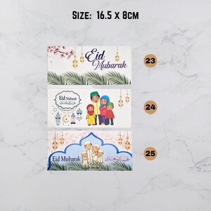 May include: Three different designs of Eid Mubarak greeting cards. Each card features a colorful illustration of a family with the text "Eid Mubarak" in English and Arabic. The cards are 16.5 inches by 8 inches.