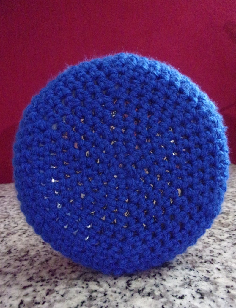 May include: A blue crocheted pot holder with a circular shape. The pot holder is made of a soft, textured yarn.