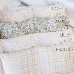 May include: Four rectangular fabric items with floral and plaid designs. The items are labelled "ROSE", "AMELIA", "LILLY", and "FRANKIE". Each item has a small tag that reads "frankie + co".
