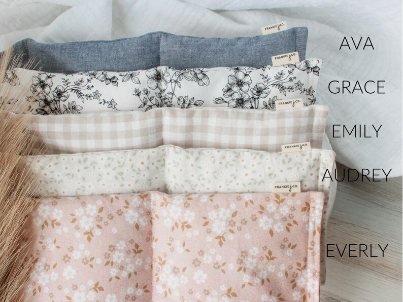 May include: A stack of five fabric items with different patterns and colors. The top item is a solid light blue, followed by a floral print, a tan gingham, a white floral print, and a pink floral print. Each item has a small tag that says "frankie & co."