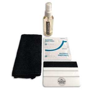 Puede incluir: Un kit de aplicación de productos que incluye un pulverizador etiquetado como "Application Spray", un paño de microfibra negro, dos almohadillas con alcohol y una espátula blanca con el texto "ACCENTREK DESIGNS".