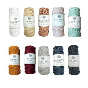 Peut inclure: Dix bobines de cordon en coton de 4 mm dans différentes couleurs, dont blanc, beige, marron, gris, vert clair, jaune moutarde, bordeaux, gris clair, gris foncé et sarcelle. Chaque bobine est étiquetée "Kabatani Macrame".